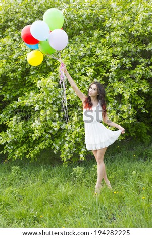 Spring colorful balloon. Portrait of young adult latin hispanic Girl holding  color balloon on spring flowers apple tree background. Cute woman full length standing on fresh green grass