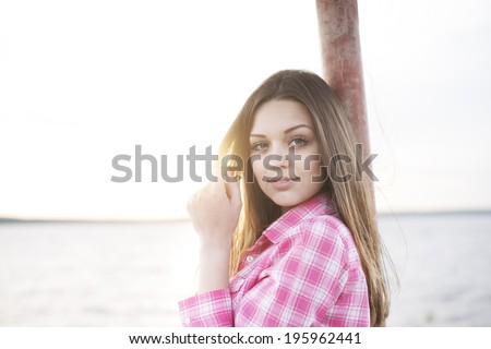 Portrait of cute caucasian beautiful girl close-up,  wind fluttering hair against sea and sun set sky background Sunset horizon seashore Copy space for inscription