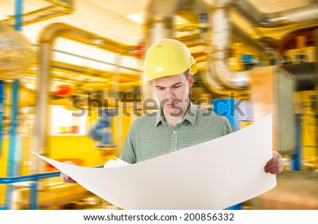 Young adult Man working in oil or gas refinery, turning on and off pipeline valve torso and hand engineer yellow holding paper plan, helmet for workers security construction worker