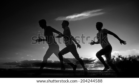 Silhouette of Three runners running along seashore against sunset cloudy sky and sea water texture background