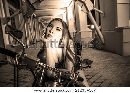 Portrait of young adult caucasian Biker girl in black shorts on a motorcycle Cute sexy woman with long white hair looking at camera Empty copy space for inscription