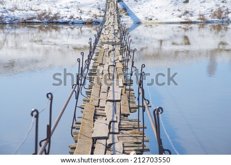 Background of old retro vintage wooden bridge from board above texture cold water in river cold winter or spring season