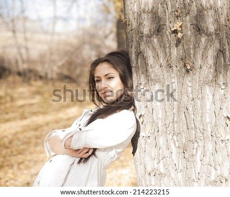 Outdoors portrait of gorgeous fall fashion latin hispanic girl. Empty Copy Space for inscription Texture trunk Empty space for inscription Cute woman with long brunette hair