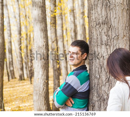 Young latin hispanic couple behind a tree an autumn symbol of quarrels misunderstandings depression divorce and separation hurt parting copy Space for inscription