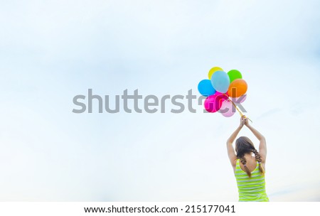 Back wiev Young Beautiful birthday girl with colorful baloons on blue cloudy sky background Empty Copy space for inscription No face Unrecognizable person