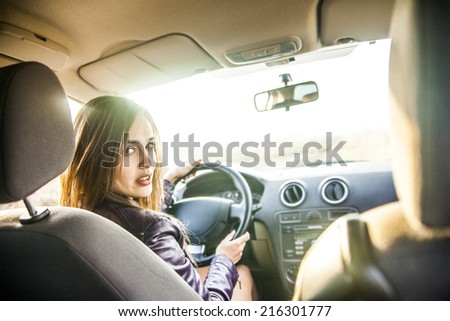 woman in car indoor keep wheel turning around smiling look at passengers in back baby seat idea taxi driver talking to police companion companion who asks for directions right to drive Documents exam