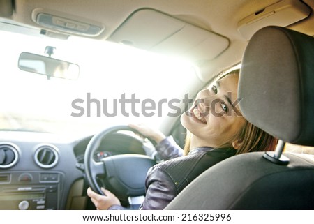 woman in car indoor keep wheel turning around smiling looking at passengers in back baby seat idea taxi driver talking to police companion companion asks for directions right to drive Documents exam
