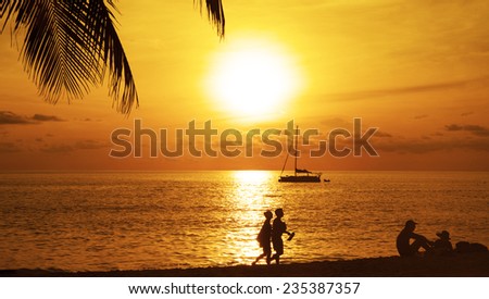 Silhouette of Two Romantic couple enjoying a beach walk along sun set beach and sit at sunset sand against water texture and sky with clouds evening background Empty copy space for inscription