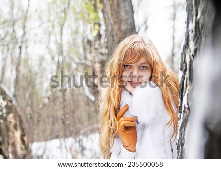 Portrait of Beautiful cute happy redhead girl face in white jacket with fur collar in the winter forest or park background . Woman looking at camera Empty copy space for inscription