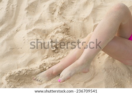 Tan slim sandy legs lying on white or yellow sand texture on hot beach near water tropical sea ocean, no face body Unrecognizable person Pink sexy swimsuit Empty copy space for inscription