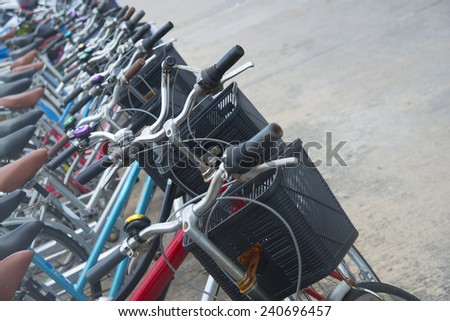 Background of Old retro vintage style aged  bicycles of service for rent. Empty copy space for inscription Black plastic box on rusty cycles standing on gray asphalt