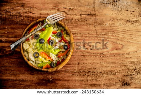 healthy vegan salad of fresh vegetables with red paprika cabbage in wooden plate on old retro vintage aged table natural  background Empty texture space for inscription