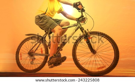 Unrecognizable person No face Mountain Biker on sky with background Man wearing yellow sport shirt sneakers shorts Empty copy space for inscription Reflection sun on yellow water texture