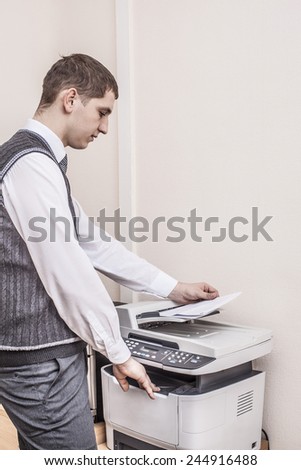 Side view midsection Portrait of young adult businessman using photocopy machine in office Business man white collar holding paper document against texture wallpaper background Empty space