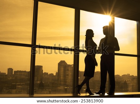 Full length silhouette of two business people stand on floor against window frame landscape of city and architecture construction background Sun shine light Empty space in office room for inscription