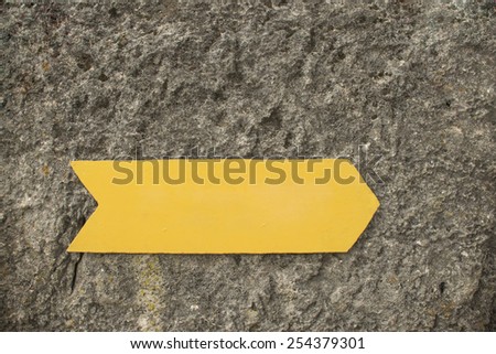 Background of empty Blank metal yellow arrow on grunge stone gray wall texture backdrop Metallic gold sign show the direction pointer