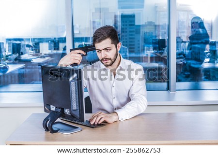 arabian asian beard young adult  businessman with black metal gun near temple head against window glass reflection in office room space look pc computer monitor watch bad sad information