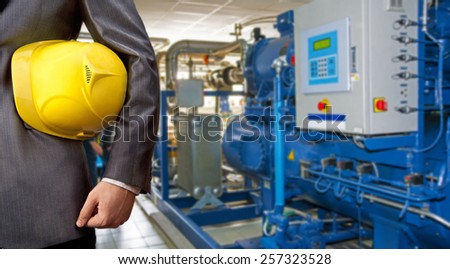 Worker engineer Man work in oil or gas refinery, turning on and off the pipeline valve torso and hand engineer yellow helmet for workers security construction worker No face Unrecognizable person