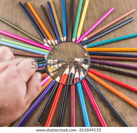 background of bunch of pencil under magnifying glass on wood table Idea of concentration and attraction to nucleus center circle radius unity concept of leadership, community, team focused on one goal