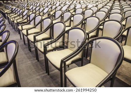 background of beige armchairs in conference hall in perspective Rows of new elegance chairs stand on brown wooden texture floor Empty seat