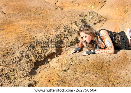 portrait of Young woman lie on crack land dry texture soil Cute freak girl paint body art or tattoo with blue flower and red flame wear black transparent clothes search water in desert parched creek