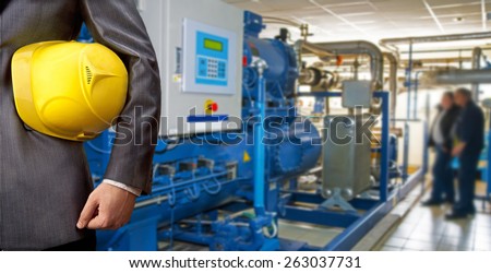 Worker engineer Man work in oil or gas refinery, turning on and off the pipeline valve torso and hand engineer yellow helmet for workers security construction worker No face Unrecognizable person