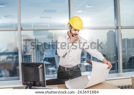 businessman architects look at paper plan business man architect near computer pc monitor in office to discuss business projects. Successful young engineer in construction yellow helmet are on table
