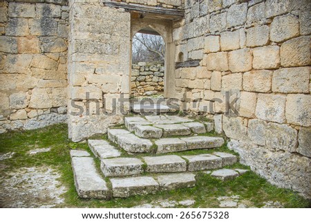 Background of ancient historical old retro vintage aged stone front yellow and gray wall texture with empty Door frame, and Staircase in antique style Fresh spring green grass Empty space No people