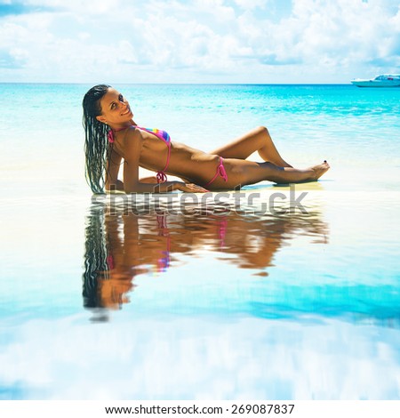 young adult girl person Exotic Hideaway Tanning Pleasure  Face of cute woman with beautiful tanned brown sexy skin body on tropical white sand beach on blue sky background with clouds Yacht on horizon
