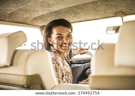 happy young african girl driver inside old retro vintage car Cute woman look back at pasangers with smiley face idea taxi driver against sunset Light shine sky Concept of exam Vehicle - second home