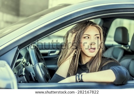 Portrait of female Young adult dream and look far away girl sitting in luxury black car Slim cute asian scary woman listening music inside black leather chair auto hand Fingers caress brunette hairs