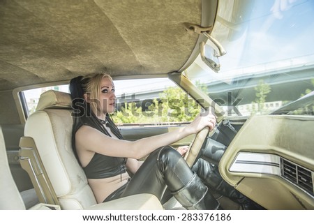 woman in car indoor keeps wheel turning around serious looking at passengers in back seat idea taxi driver talking to police companion companion who asks for directions right to drive Documents exam