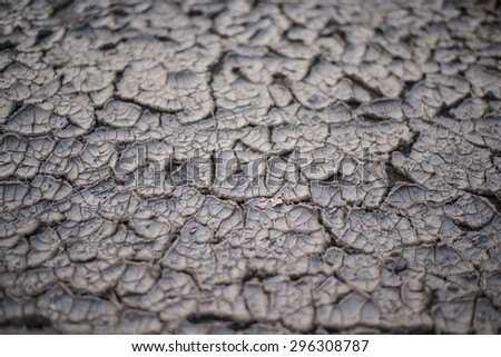 Dry lake bed with natural texture of cracked clay in perspective floor. Death Valley field . background. Selective focus on black soil dark land. Idea concept symbol disaster ecology in nature