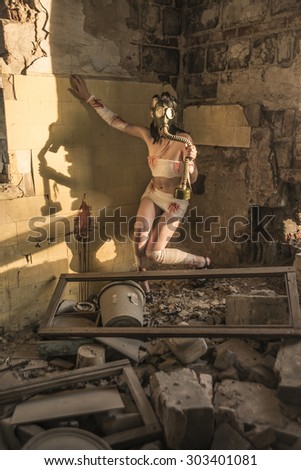 Full length Woman with gas mask in a grunge background Post apocalypse girl stand in angle abandoned dirty yellow wall with shadow from sun light Toxic trash in dusk room Window fram lie on floor