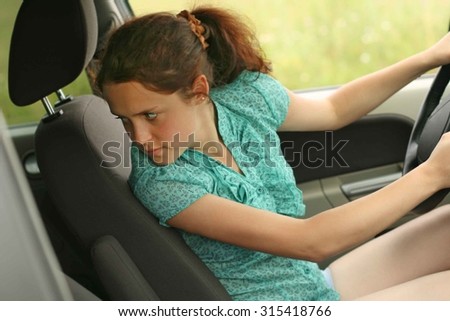woman in car indoor keeps wheel turning around serious looking at passengers in back seat idea taxi driver against sunset rays Light shine sky Concept of exam Vehicle - second home the girl