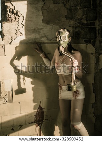 Full length Woman with gas mask in a grunge background Post apocalypse girl stand in angle abandoned dirty yellow wall with shadow from sun light Toxic trash in dusk room