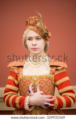 Full length woman in 16th century style red dress Young adult girl alone walk along vintage old retro building Pride emotion on face Historical costume - Dress Spanish court elegant luxury lady