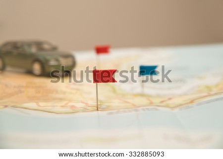 Pushpin and small, toy car on map for travel concept. pointing the location of destination point