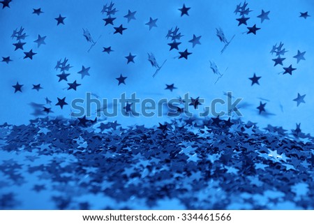 Blue confetti in the form of stars flying or fallen on  background Empty space for inscription, people or objects