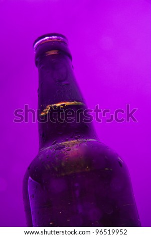 Bottle with alcohol on purple background