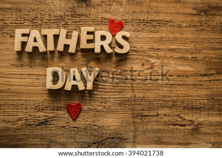 Happy Fathers Day wooden letters on a rustic wood background. empty space for inscription or objects. two red heart