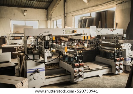 electric modern computerized machine for punching sheets of hardboard or chipboard indoors workshop. industrial background. interior inside room space.