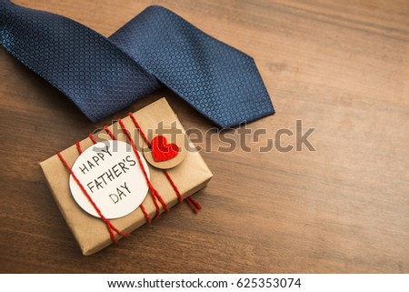 Gift box with red heart and ribbon, blue tie and Father\'s day card . Striped tie near present box. Best quality gifts for dads. Happy father\'s day idea, sign, symbol. holiday background