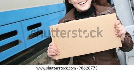 Girl with a cardboard sign on the background of the railway bridge girders