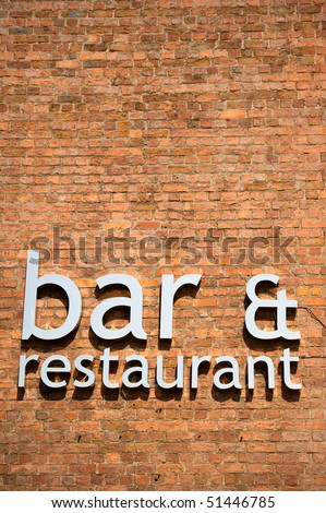 Bar and restaurant sign on brick wall with copy space.