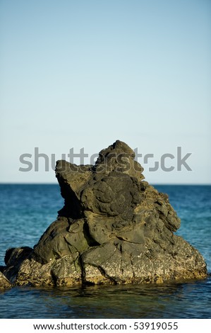 Rock in the sea with sky and copy space.