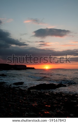 sun setting over black point Anglesey with copy space.