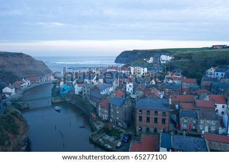 Staithes from high vantage point with fading evening light and smoke from the houses.