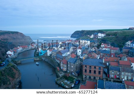 Staithes from high vantage point with fading evening light and smoke from the houses.
