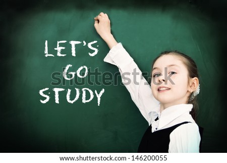 Education. Elementary school student at the blackboard. School concept - Let's go study